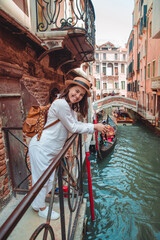 Fototapeta na wymiar portrait of smiling woman looking at canal with gandola