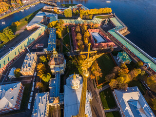 Naklejka premium Russia, St. Petersburg, Aerial landscape of Peter and Paul cathedral at sunset, walls of fortress, Golden autumn, panorama landscape, golden spire with cross and angel, drawbridges, river Neva