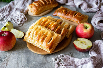 Puff pastry with apples and cinnamon for breakfast for the family on a gray background. Close-up
