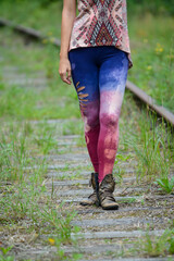 Fototapeta premium Colorful stylish leggings, on woman legs, walking on a railway