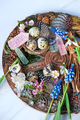 Altar for spring Ostara sabbath. wiccan wheel of the year with flowers, crystals, eggs. Esoteric Ritual for Ostara, pagan holiday. Magical Spring equinox. close up. top view - obrazy, fototapety, plakaty