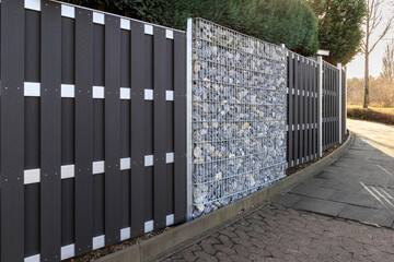Modern gabion wall system with stones as element of garden or house wooden metal fence