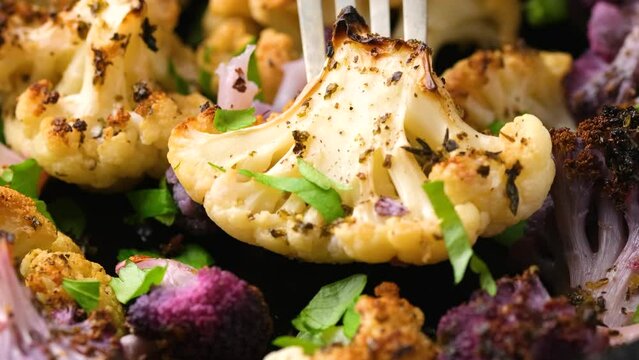 Eating Roasted purple, white cauliflower with fork