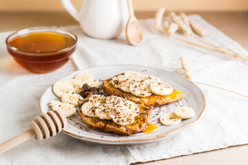 Ready to eat sandwiches with honey, banana and chocolate on a plate on the table. Homemade vegetarian snack