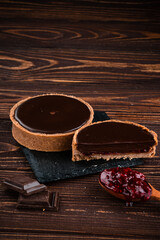 round tartlet in butter cream, baked tartlet dessert, chocolate tartlet with berry
