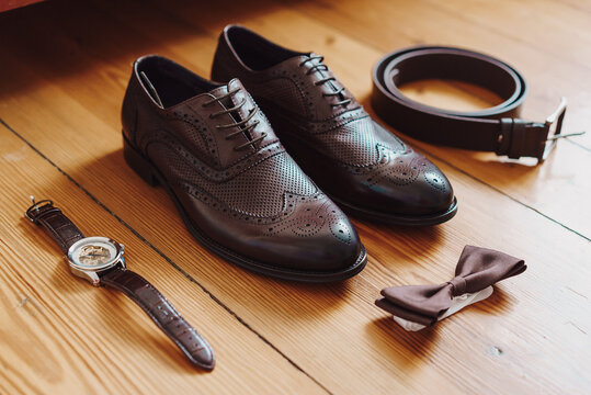 Accessories for the groom's wedding day. Brown leather shoes, belt, watch. Men's fashion