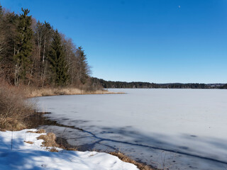 Schnee- und Eislandschaft in Oberbayern. Zugefrorener Kirchsee, kleiner Moorsee bei Sachsenkam...