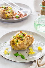 Appetizing twice-baked potatoes in their skins with cheese and bacon crumbs on plates on a wooden table. Flexitarian Diet. Close-up. Vertical view