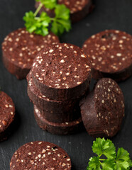 Raw Black Pudding with parsley on rustic stone board