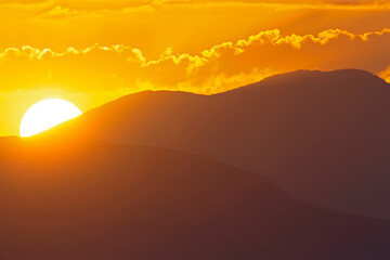 Obraz premium The sun rising early in the morning above the hills of Greece.