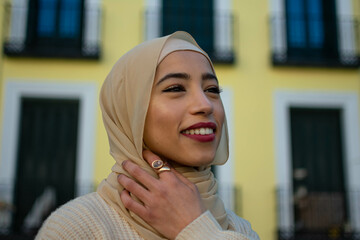 Portrait of muslim woman face outdoors, close-up. Arab girl in hijab posing at street, looking at...