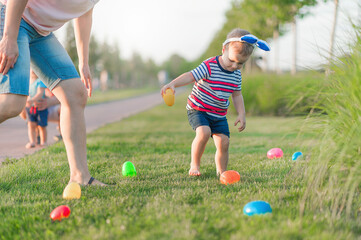 Toddler eggs hunters close-up. Children activity for Easter in nature..