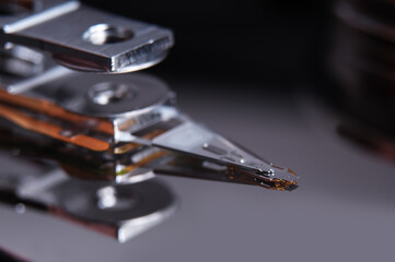 Open hard disk drive with magnetic head closeup.