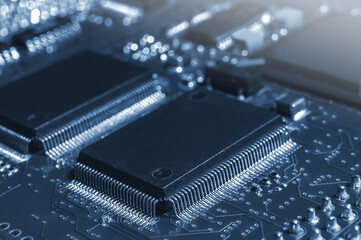 Closeup of Printed Circuit Board with processor, integrated circuits and many other surface mounted passive electrical components.