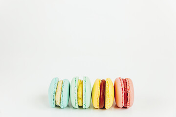 Sweet almond colorful pastel pink blue yellow green macaron or macaroon dessert cake isolated on white background. French sweet cookie. Minimal food bakery concept. Flat lay top view copy space