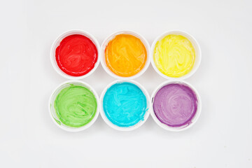 Cans of paint. Rainbow. Multicolored colours. Blue, yellow, orange, green. White background
