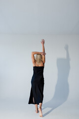 blonde girl in a black dress on a white background