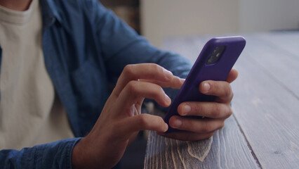 A handsome man is watching something on the phone and looking to the camera 