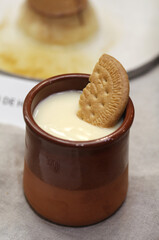 postre casero de natillas con galleta en vaso de barro