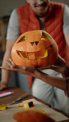 A young lady is showing a ready-made pumpkin