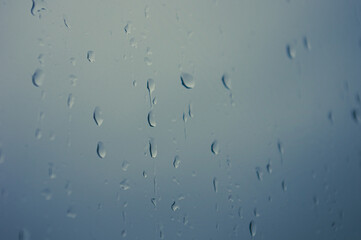 Natural summer background - raindrops on the window glass, close up.
