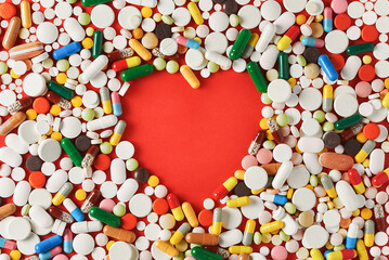 Fototapeta na wymiar heart shape is formed by a large number of colorful tablets, pills and capsules