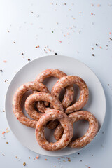 Raw Chicken Sausages with spices, close-up on white background.