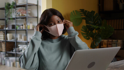 A beautiful lady is putting a protective mask on her face