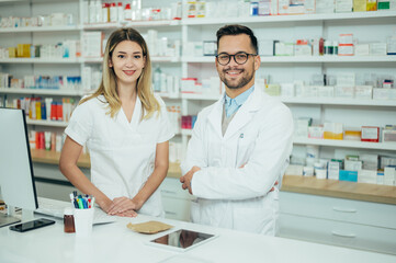 Happy young male and female colleagues pharmacist working in a pharmacy