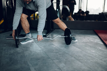 Middle aged man lifting barbell in the gym