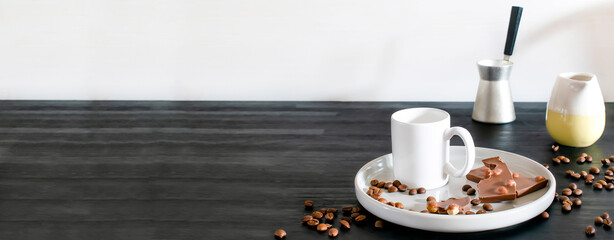 white espresso cup, mug, chocolate, coffee beans on plate kitchen table, utensils dishware, coffee pot on black wooden shelf. Early morning home hot beverage breakfast, mockup logo design copy space