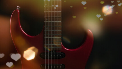 Obraz na płótnie Canvas a red electric guitar with light heart emojis