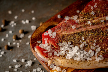 Raw T-bone steak cooking on stone table