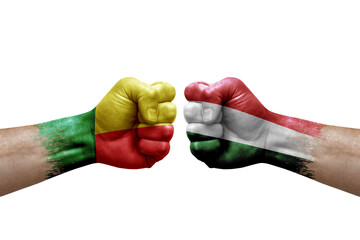 Two hands punch to each others on white background. Country flags painted fists, conflict crisis concept between benin and hungary