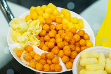 Close-up of various crispy chips in plate, fast food snacks