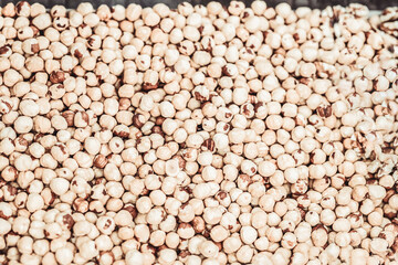 Hazelnut background, peeled hazelnuts top view, soft focus
