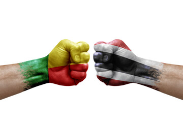 Two hands punch to each others on white background. Country flags painted fists, conflict crisis concept between benin and thailand