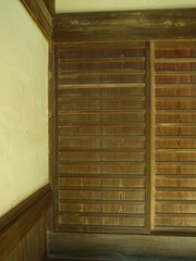 古寺の土間の板戸と白壁