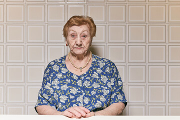 Portrait of an old woman in the kitchen of her house.