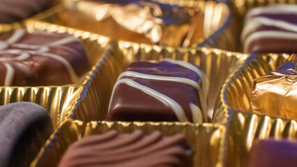 Delicious chocolate candies in packaging background