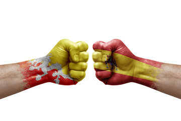 Two hands punch to each others on white background. Country flags painted fists, conflict crisis concept between bhutan and spain