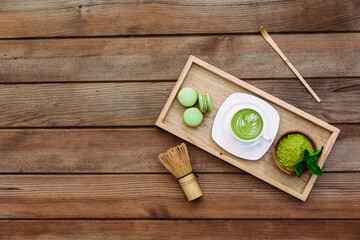 Japanese green matcha latte, matcha powder, bamboo whisk for whipping on old wooden board. Matcha tea healthy organic product rich of antioxidants. Top view.