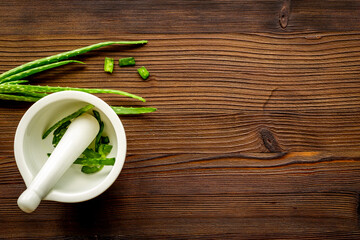 Aloe vera green leaves and slices in white mortar