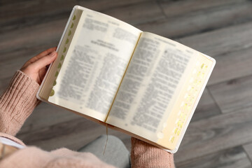 Fototapeta na wymiar Above view of woman reading Bible indoors, closeup