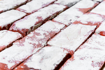 Grungy brick wall with remnants of whitewash and natural defects, top side view. It can be used as...