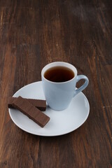 Obraz premium Chocolate Wafer on Wooden Plate, Served with Tea, Copy Space