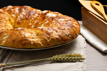 close-up of a handmade roscon de reyes. typical christmas cake on wooden table and box with utensils
