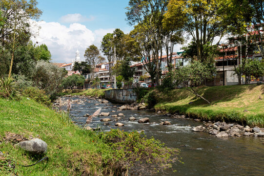 View of the river Tomebamba and public park along the river that crosses the historic center city of Cuenca with church Todos Santos on background. Ecuador