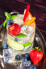 Glass with a cooling drink of berries and ice. Misted glass. Air bubbles on glass of glass