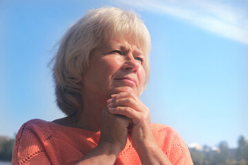 Portrait of a pensive senior woman in autumn park